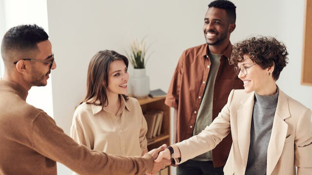 people shaking hands in an office